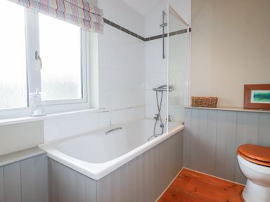 A bathroom with a bathtub, toilet, and shower at The Mizzen in St Endellion near Port Isaac