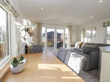 A living room with sofas and dining table at Bluebell Lodge in Warton