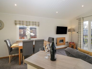 A dining room with a table and chairs at Bluebell Lodge in Warton