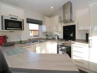 A kitchen with cabinets and appliances at Bluebell Lodge in Warton