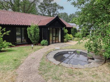 An outdoor area with a pond and a gravel path at Owl Cottage Kettleburgh near Framlingham