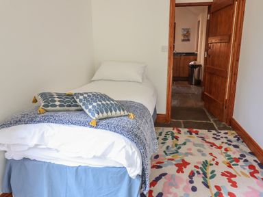 A bedroom with a bed and a door at Owl Cottage Kettleburgh near Framlingham