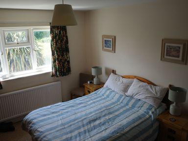 A bedroom with a bed and lamps at Badgers Cliff in Polzeath