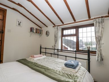 A bedroom with a bed and bookshelf at Magpie Cottage Worcester