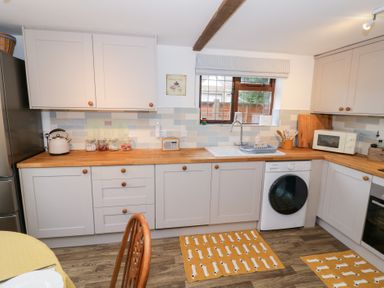 A kitchen with wooden countertop and appliances at Magpie Cottage in Powick near Callow End