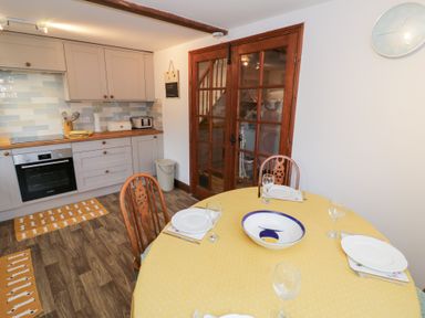 A kitchen with a table and chairs at Magpie Cottage in Powick near Callow End