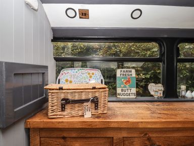 A wooden table with a basket and decorative items at The Bus on the Hill