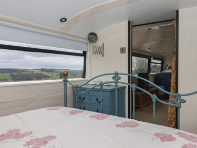 A bedroom with a bed and a blue chest of drawers at The Bus on the Hill