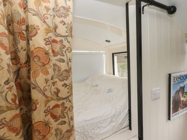 A bedroom with a bed and curtain at The Bus on the Hill