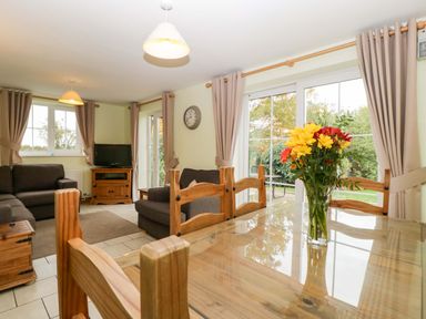 A dining room with a table and chairs at Orchard Cottage Corse near Gloucester