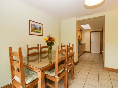 A dining room with a table and chairs at Orchard Cottage in Corse near Gloucester