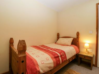 A bedroom with a single bed and bedside table at Orchard Cottage in Corse near Gloucester