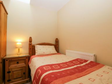 A bedroom with a single bed and nightstand at Orchard Cottage Corse near Gloucester