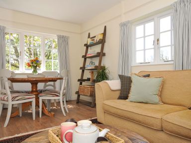 A living room with a dining table and chairs at Copper Mine Cottage Trelill near Port Isaac