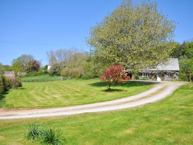 A house with a driveway and trees at Copper Mine Cottage, Trelill near Port Isaac