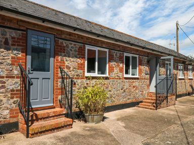An exterior view of a building with steps and a planter at The Milk Shed Plymtree