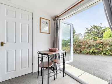 A dining area with a table and chairs at The Nook in Praa Sands
