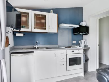 A kitchen with appliances and cabinets at The Nook in Praa Sands