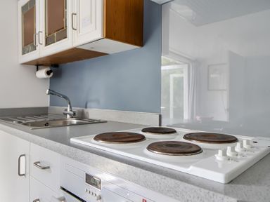 A kitchen with a stove and sink at The Nook in Praa Sands