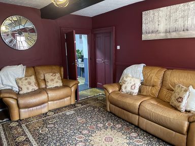 A living room with sofas and a mirror at High Dyke Cottage