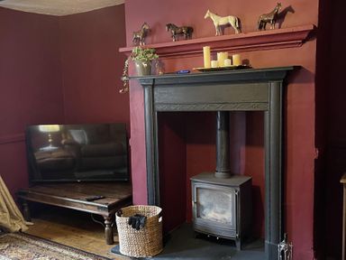 A living room with a television and fireplace at High Dyke Cottage