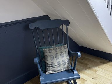A rocking chair with a pillow in a room at High Dyke Cottage