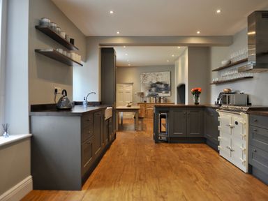 A kitchen with shelves and a table at ASH HOUSE in Wincanton