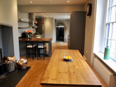 A kitchen with a wooden table and stools at ASH HOUSE Wincanton
