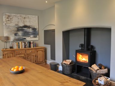 A dining room with a table and a stove at ASH HOUSE in Wincanton