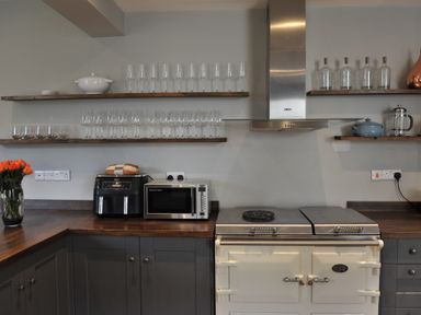 A kitchen with shelves and appliances at ASH HOUSE in Wincanton