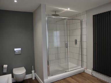 A bathroom with a shower, toilet, and towel rail at ASH HOUSE Wincanton