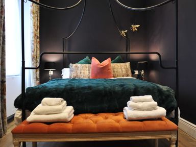 A bedroom with a bed, bench and towels at ASH HOUSE in Wincanton