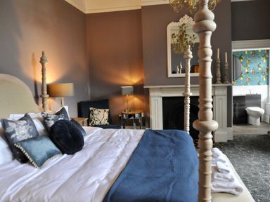 A bedroom with a bed and armchair at ASH HOUSE in Wincanton