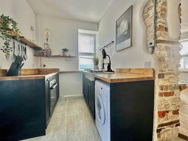 A kitchen with a sink and washing machine at the property in location