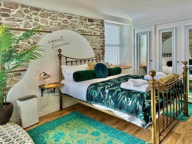 A bedroom with a bed, bedside table, and a plant at an unknown property in an unknown location