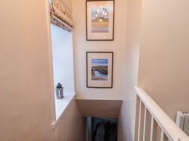 A hallway with photos and a lantern at Corner Cottage in Seahouses