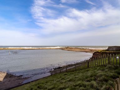 A view of a shoreline with water at Corner Cottage in Seahouses
