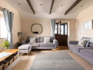 A living room with a sofa and ottoman at The Granary, Engollan near St Merryn