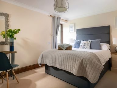 A bedroom with a bed and a desk chair at The Granary near St Merryn