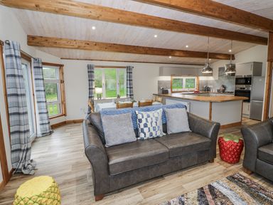 A living room with a sofa and dining area at Willow Lodge in Admaston near Abbots Bromley