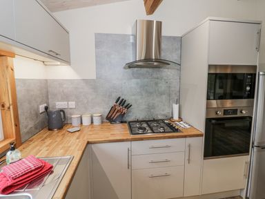 A kitchen with cabinets, a gas stove and utensils at Willow Lodge Admaston near Abbots Bromley