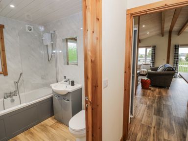 A bathroom with a bathtub and sink at Willow Lodge in Admaston near Abbots Bromley