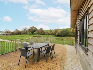 An outdoor seating area with a table and chairs at Willow Lodge in Admaston near Abbots Bromley