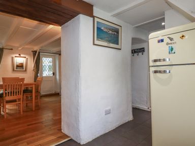 A kitchen with a dining table and chairs at Blowing House Cottage Perranporth