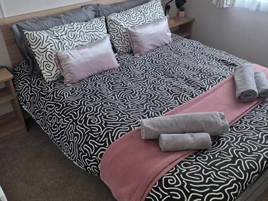 A bed with decorative pillows and towels at an unspecified location