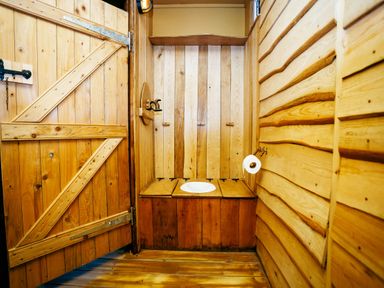A bathroom with a toilet and wooden walls at 