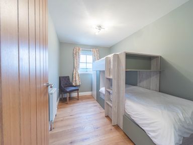 A bedroom with a bunk bed and chair at the property in location
