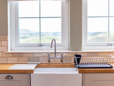 A kitchen sink with a tap and draining rack at The Old Barn in Manchester