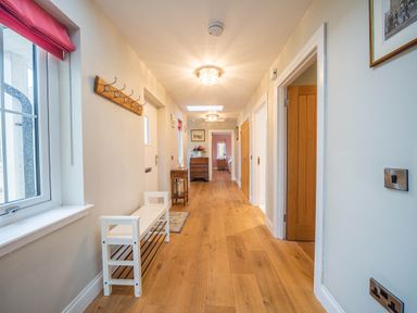 A hallway with a coat rack and bench at The Old Barn in Manchester
