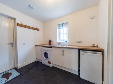 A laundry room with a washing machine and sink at The Old Barn in Manchester
